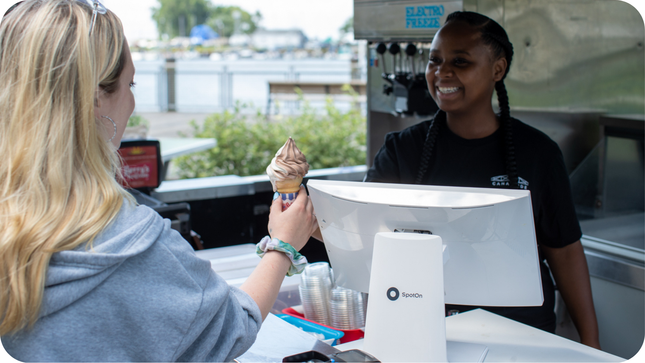 Quick-service staff worker serving ice cream to a guest at the counter.