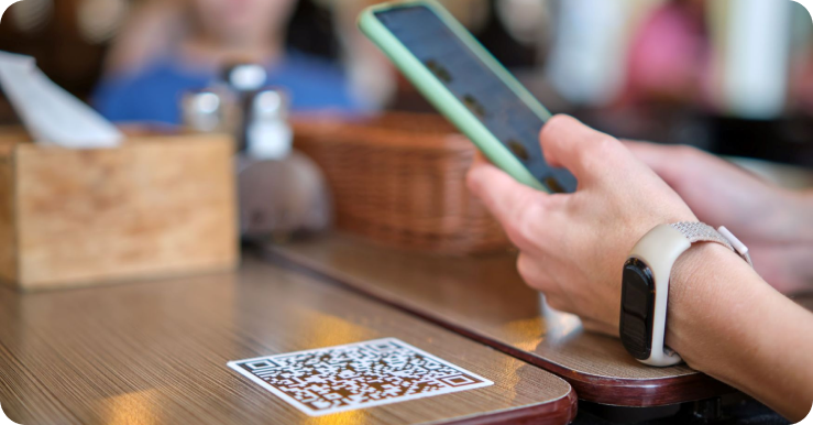 Guest scanning a QR code on a table in a casual restaurant.