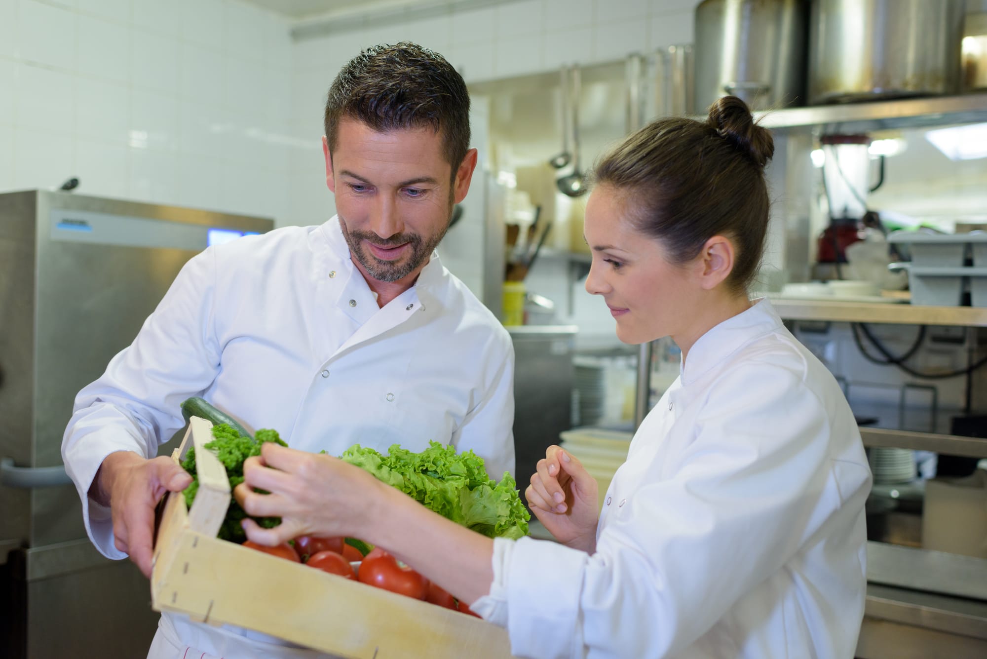 Two chefs in a Green Michelin restaurant inspecting vegtables.