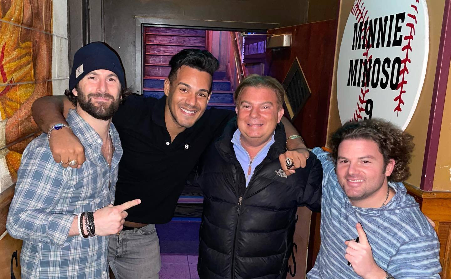 The three Strauss brothers with Charlie Minoso posing at Sluggers bar