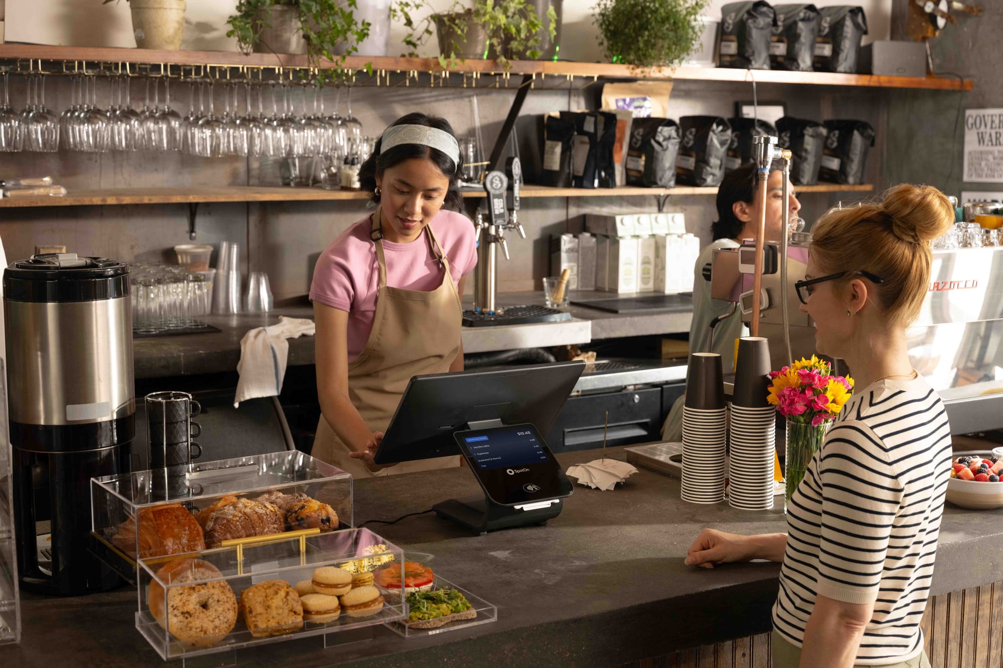 A restaurant worker rings up a customer at a coffee shop