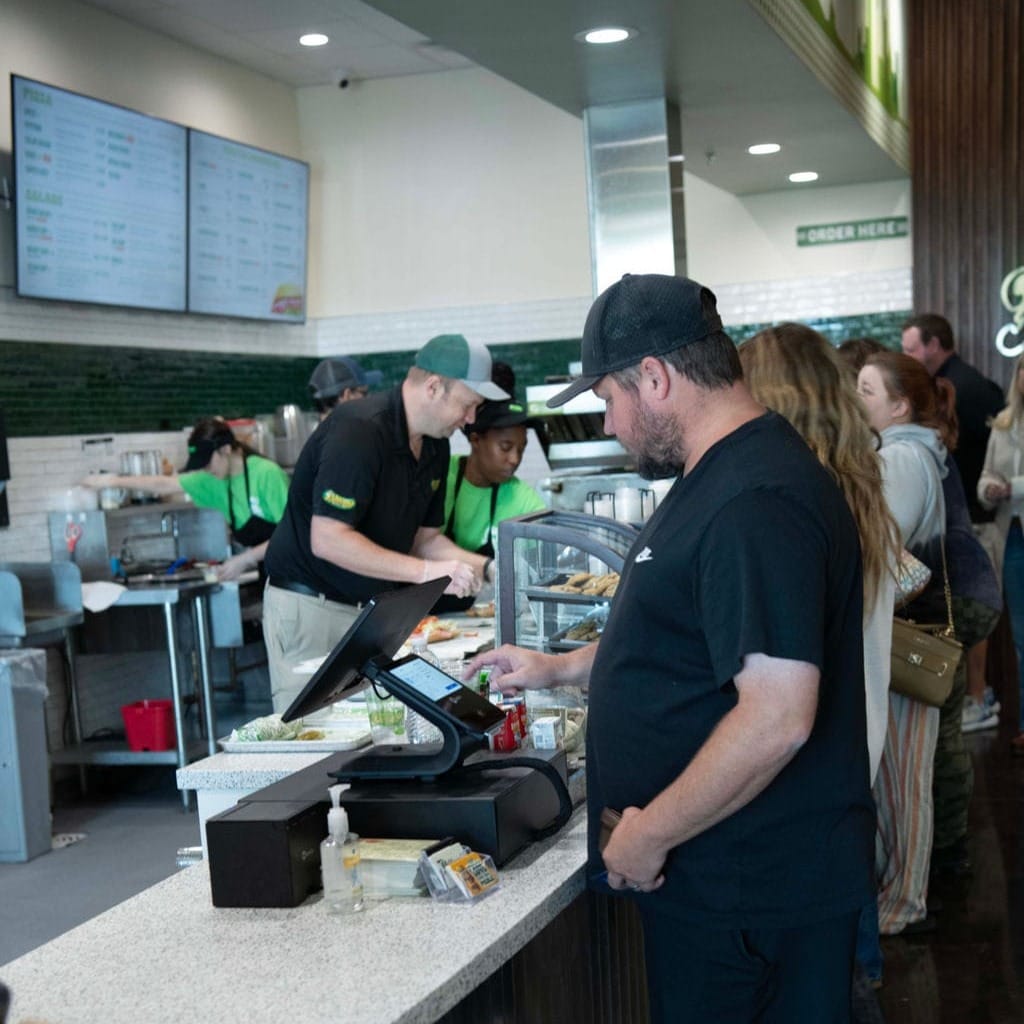 Customer paying at the POS at Pickleman's restaurant.