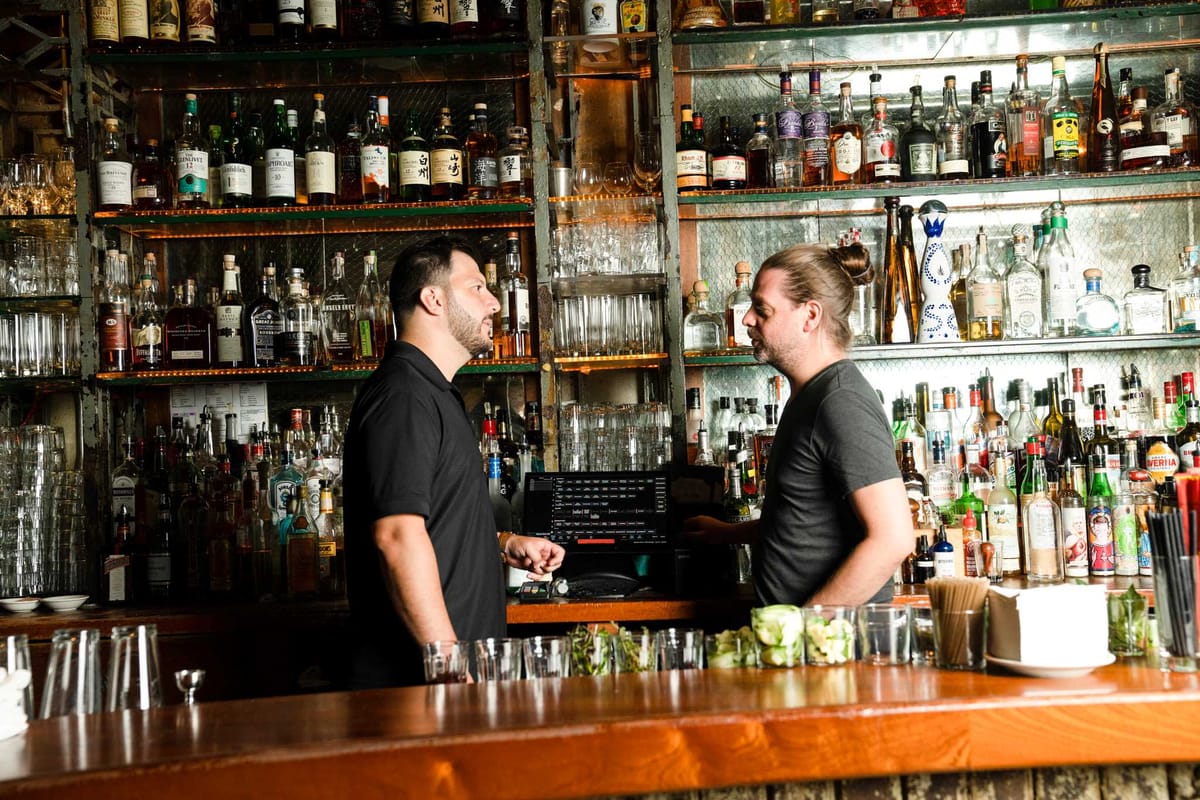 Ben Gliner from SpotOn meets with a bartender at a restaurant to discuss their restaurant POS
